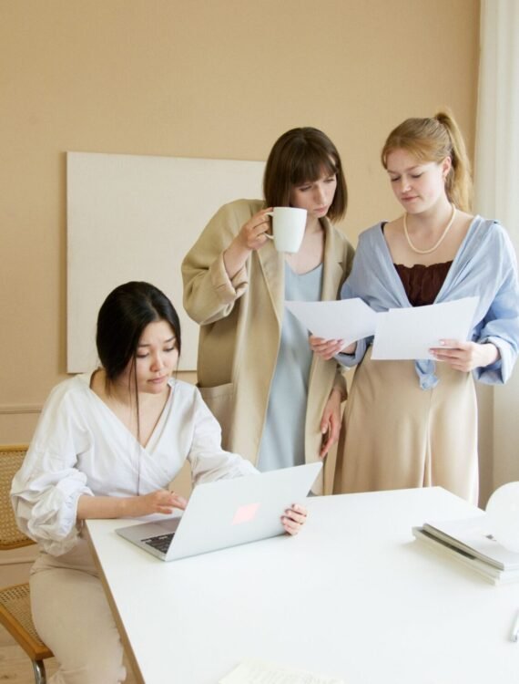 Med spa professionals reviewing documents and a laptop with a marketing consultant